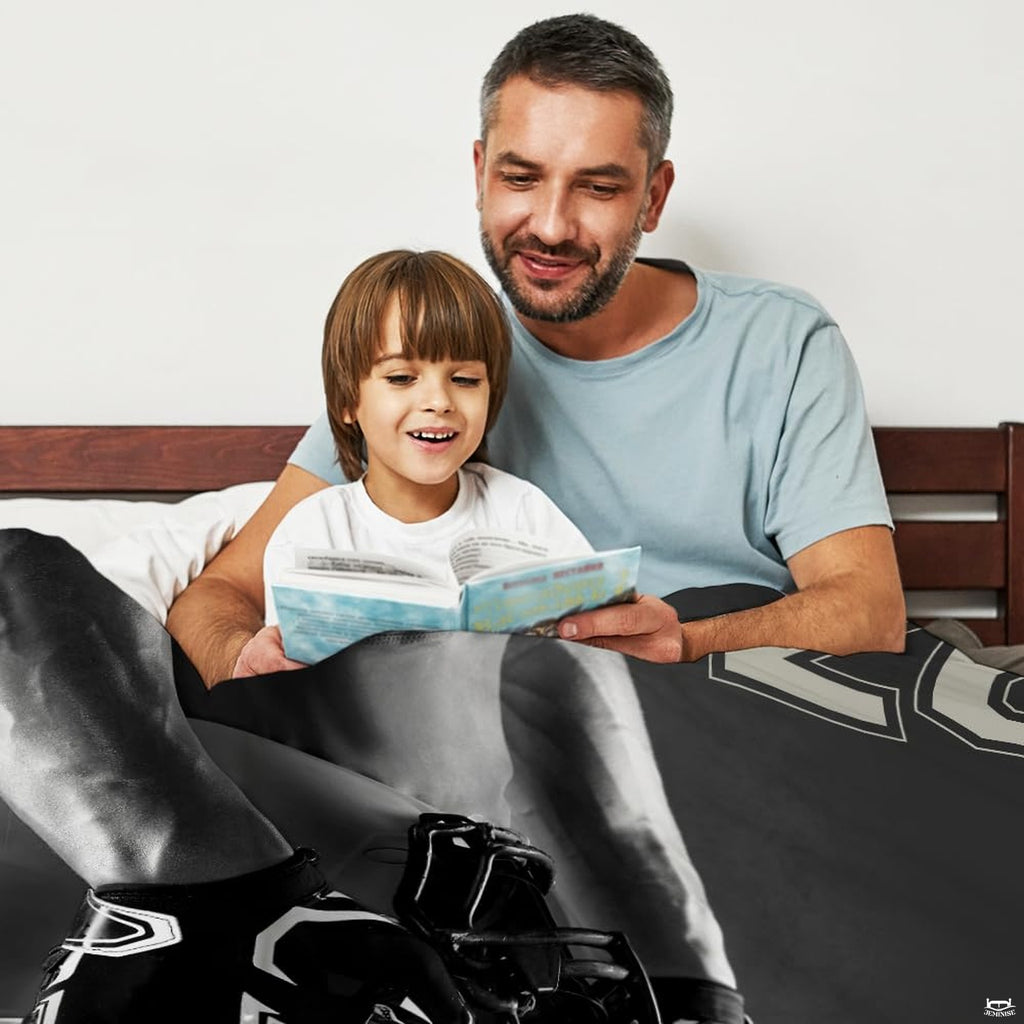 Close-up perspective of athletic gloves and football helmet on black and white throw blanket