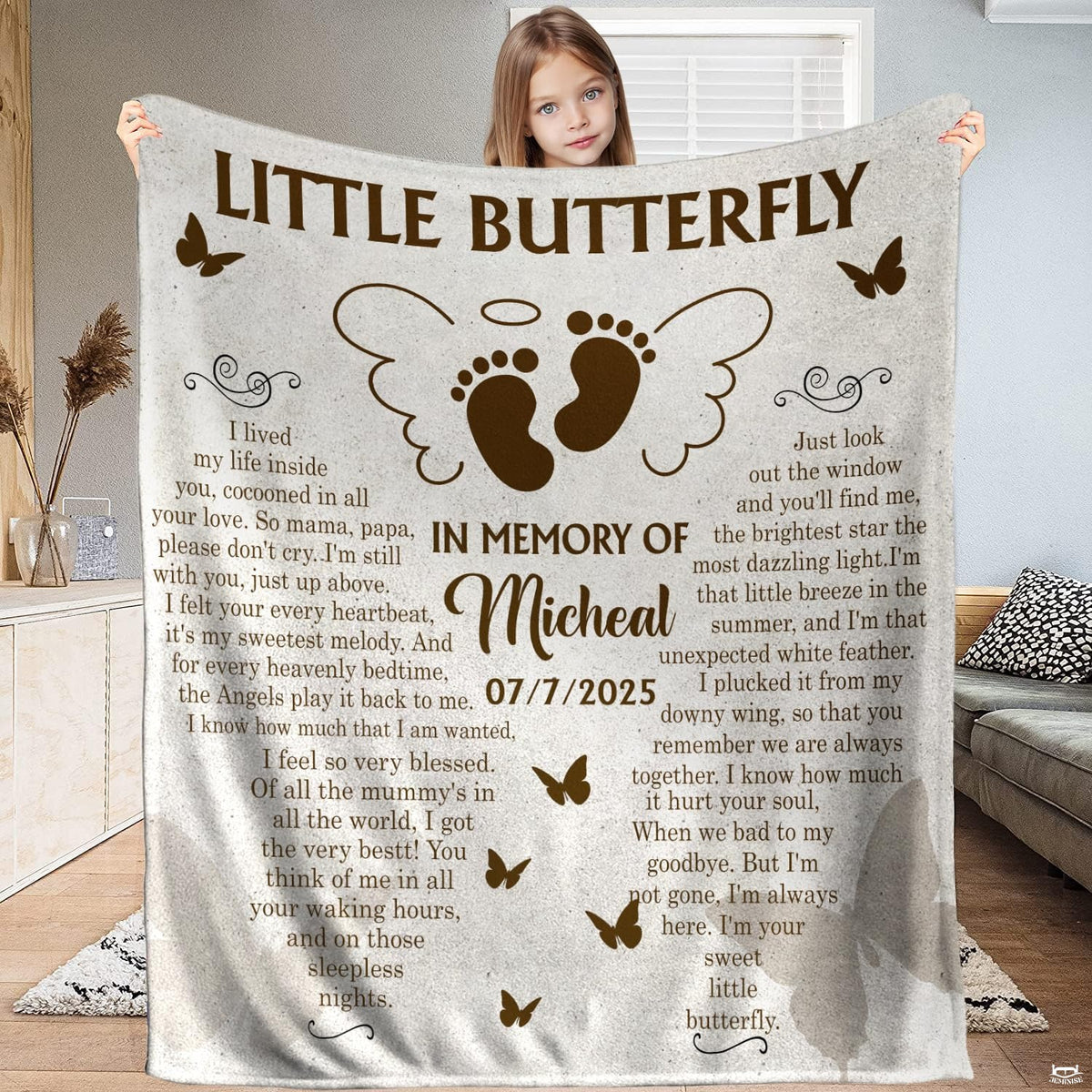 Full view of winged infant footprints memorial butterfly blanket held up indoors.