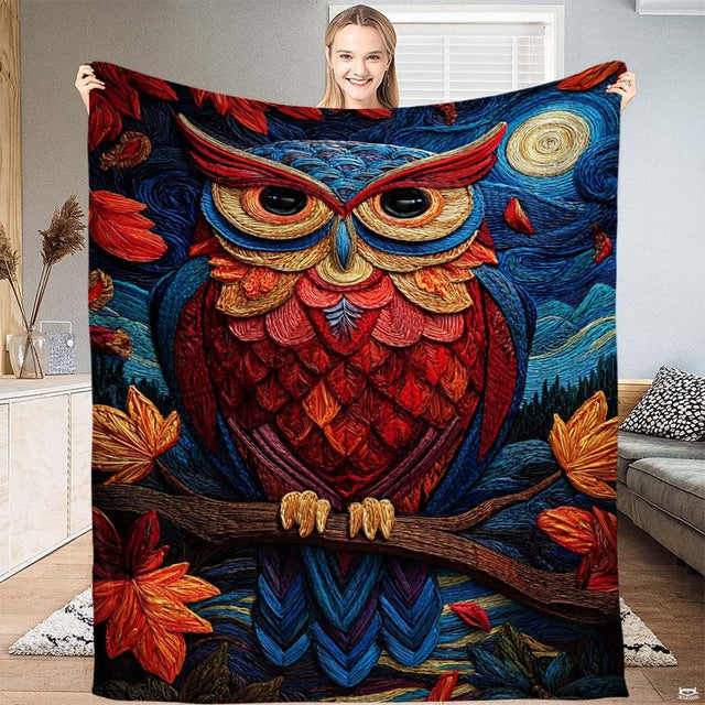 Textured colorful owl perched on a branch under a full moon with autumn leaves on a throw blanket