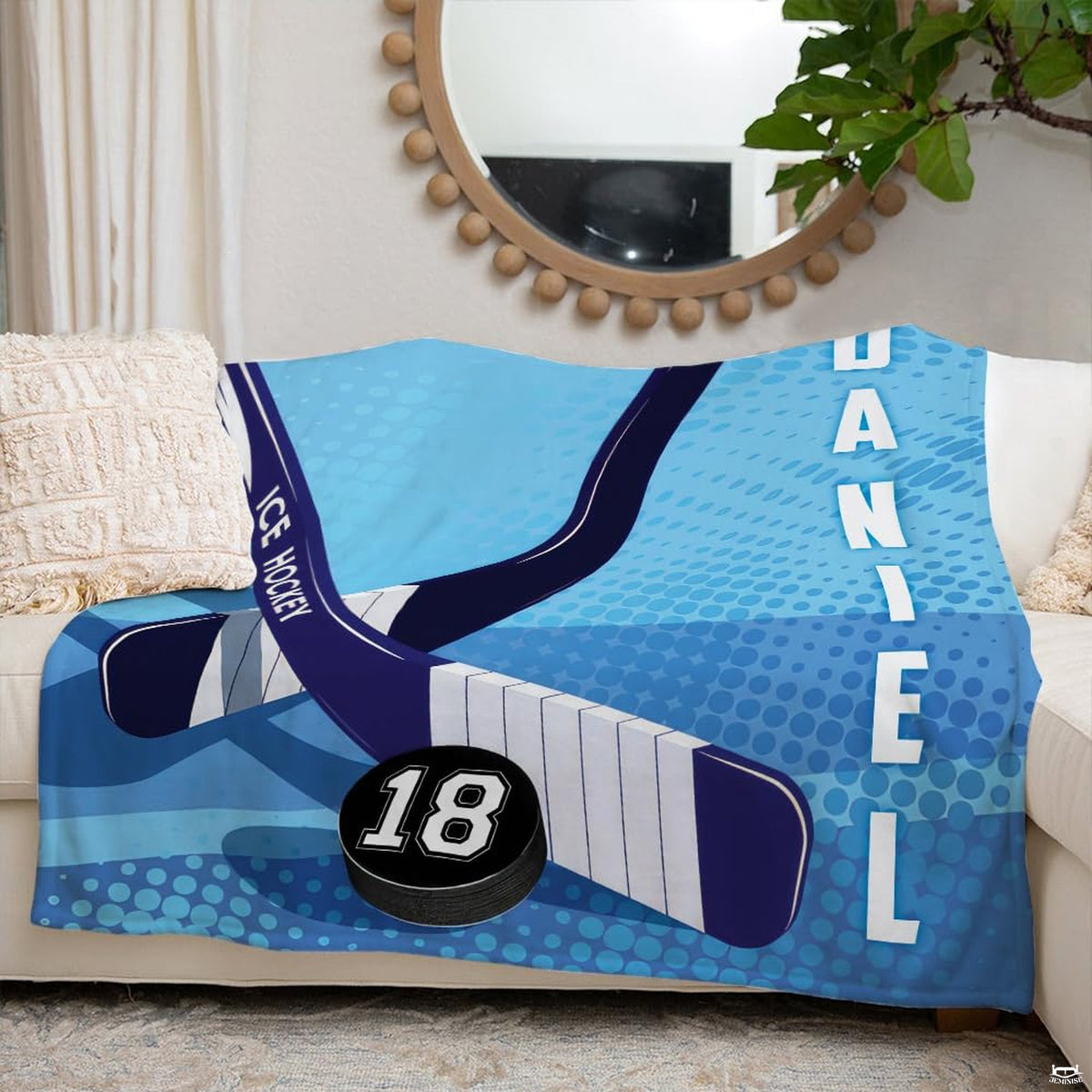 Hockey sticks and puck sports blanket styled neatly across an ivory living room couch.