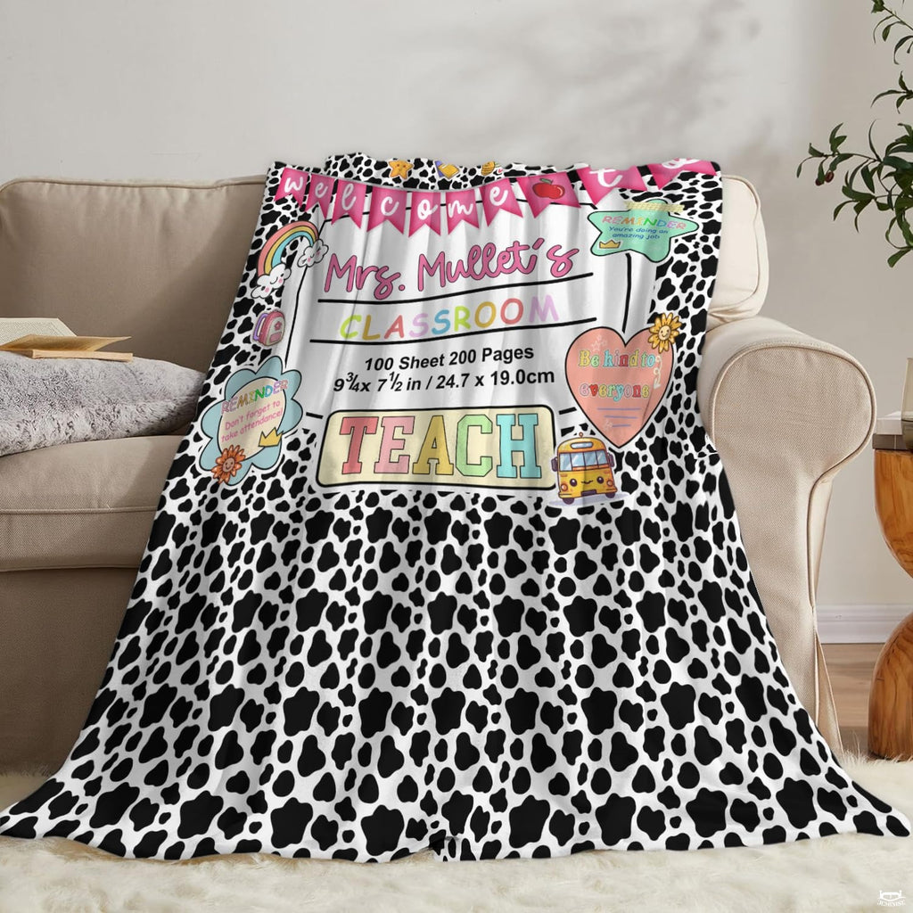 Living room sofa displaying the spotted educator school throw blanket draped over furniture.