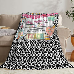 Living room sofa displaying the spotted educator school throw blanket draped over furniture.