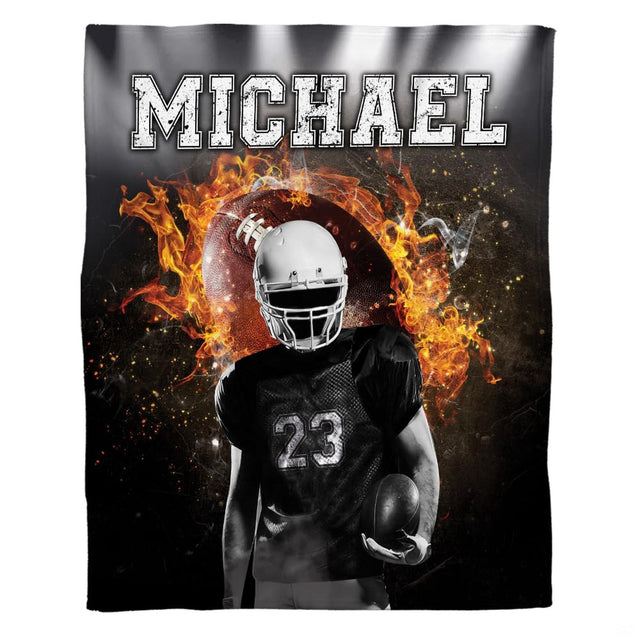 Woman holding open flaming football throw blanket showing fiery flames and distressed typography