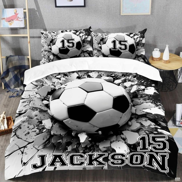 Close-up view of soccer bedding detailing textured soccer ball panels, concrete rubble fragments, and varsity lettering