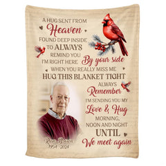 Living room staging of red cardinal sympathy throw blanket draped over an armchair beside a side table.