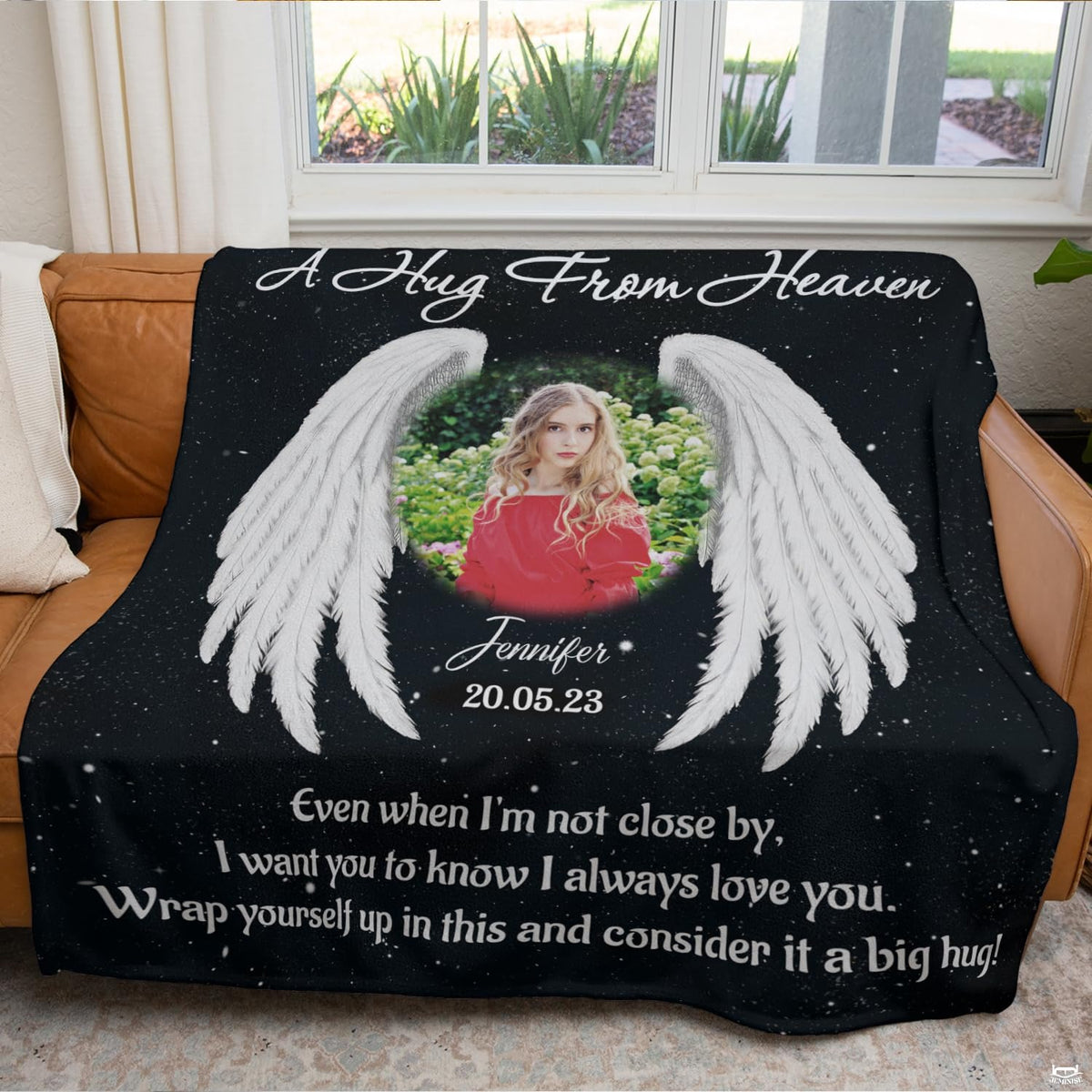 Memorial angel wings throw blanket draped across brown leather living room couch