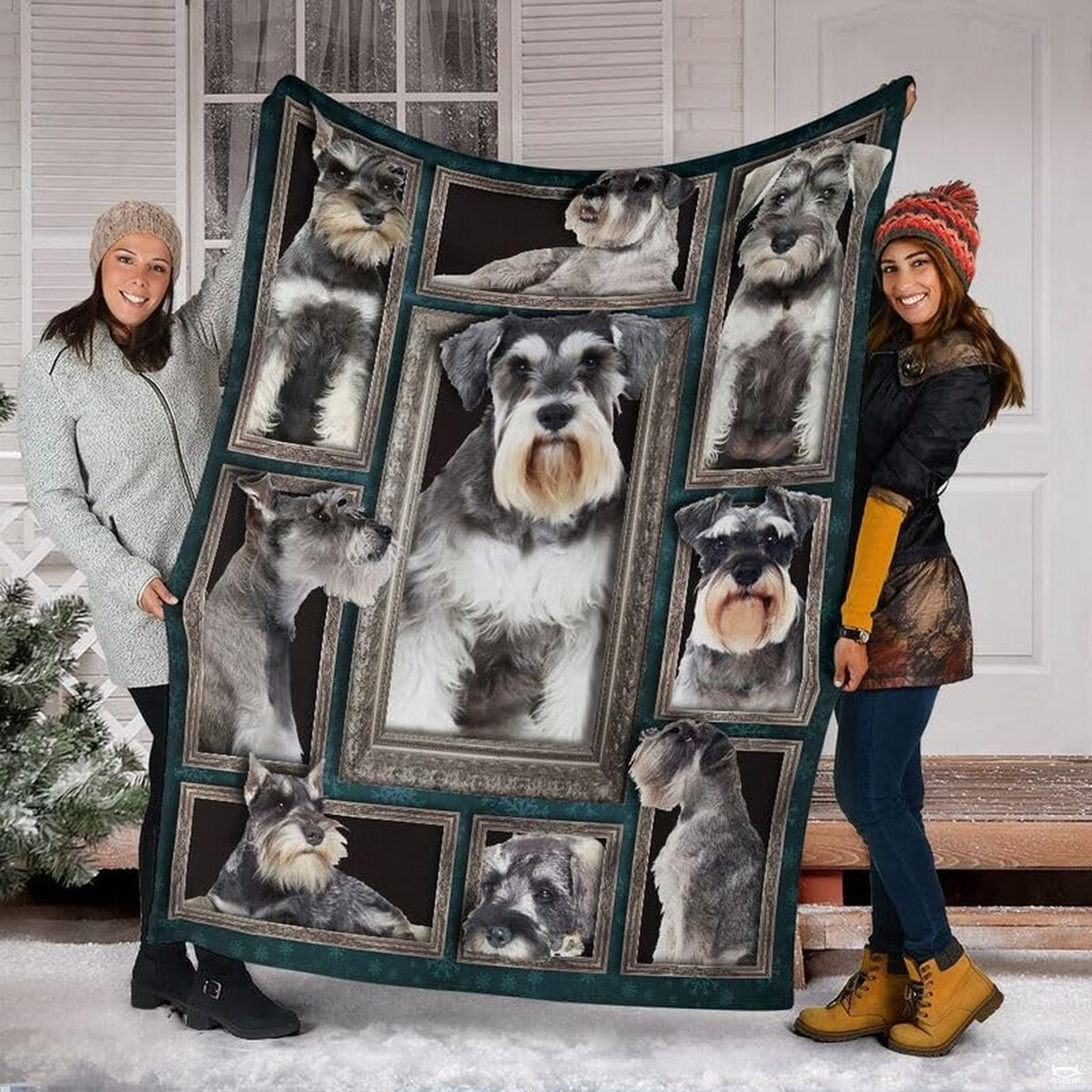 Two models displaying the Miniature Schnauzer blanket outside a snowy winter home entrance.