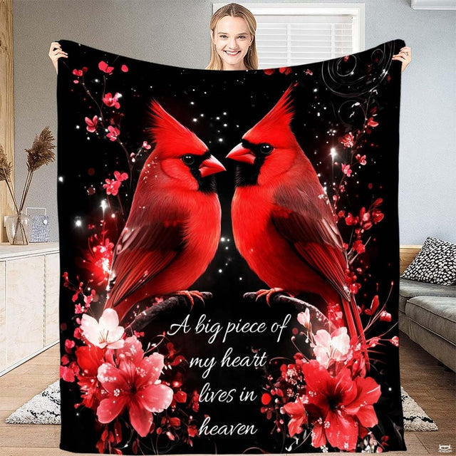 Red cardinals throw blanket featuring pair of scarlet birds on blossom branch at night.