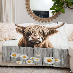 Bedroom styled with daisy fence Highland cow throw blanket displayed across rustic bedding