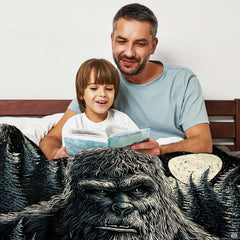 Close-up detail of the printed sasquatch facial artwork and glowing lunar texture on the throw blanket