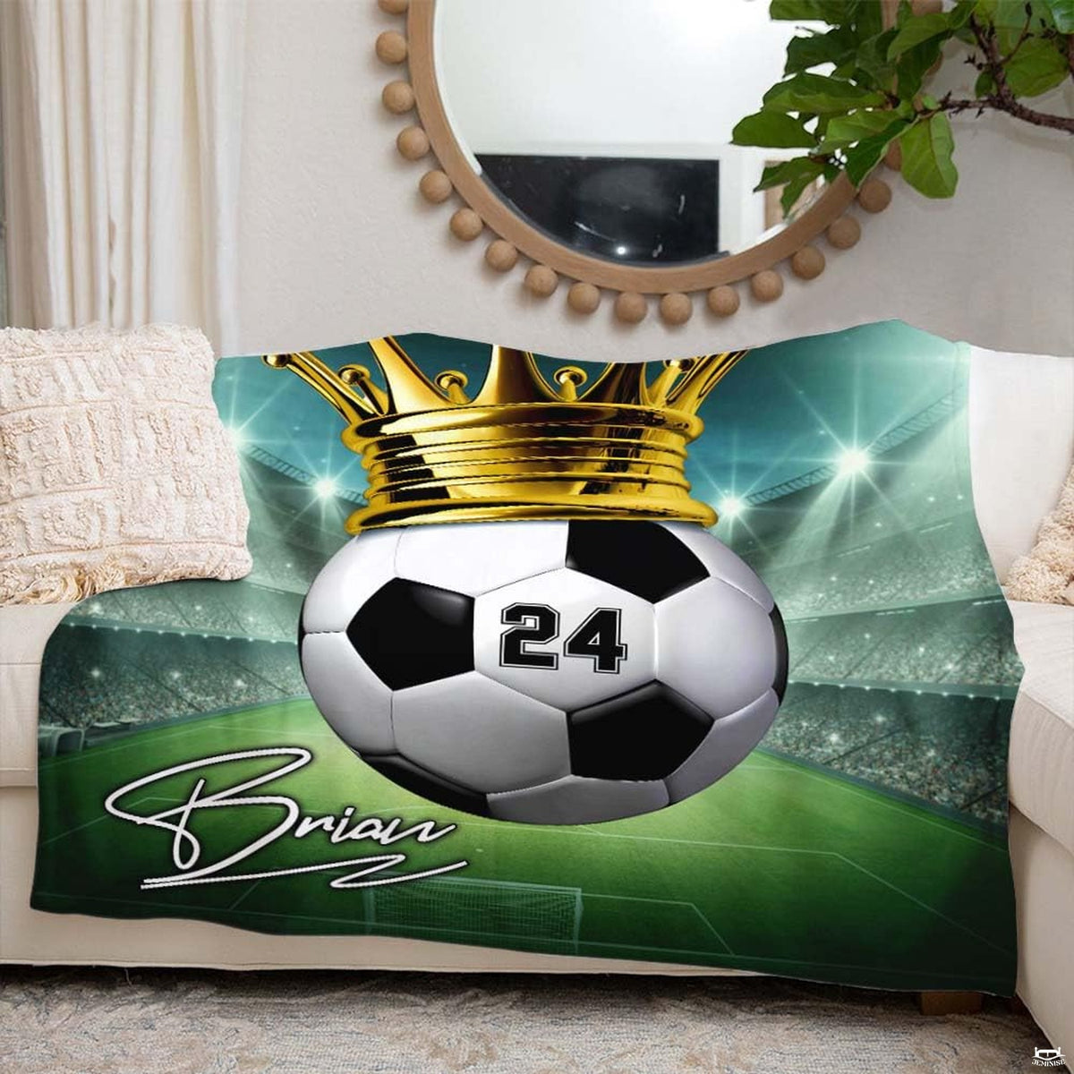 Crowned soccer ball design blanket draped stylishly over living room couch beside round mirror.