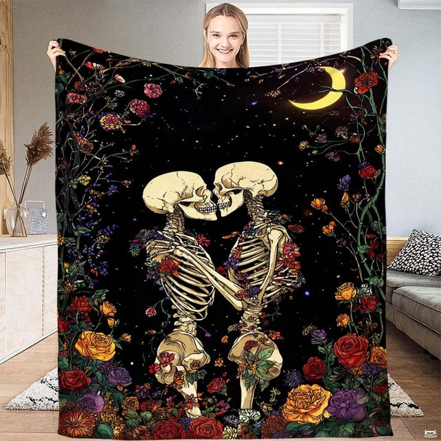 Skeleton lovers kissing midnight garden throw blanket held open by woman