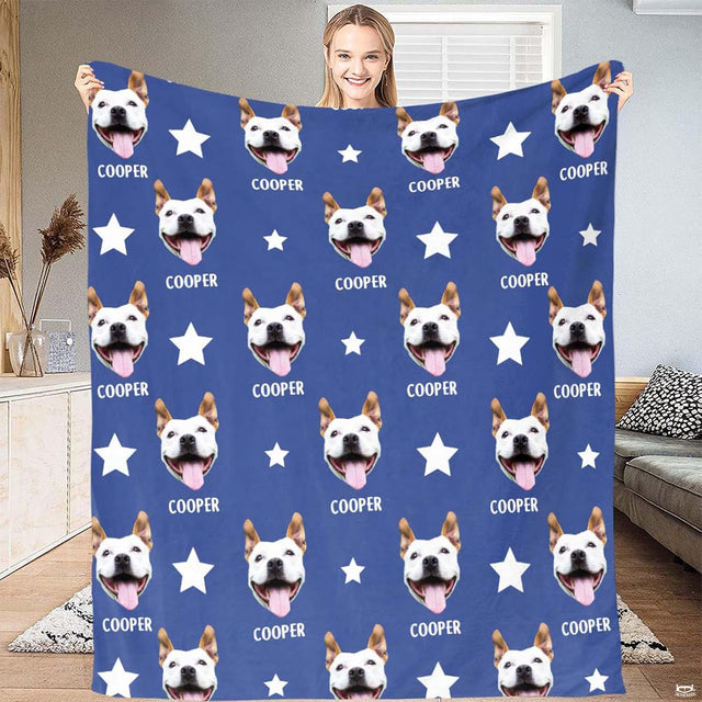 Smiling white and tan dog portrait cutout with tongue out and white stars over royal blue bedding.