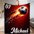 Person displaying the flaming soccer ball artwork with orange fire trail on deep crimson.