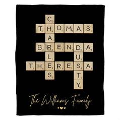 Full flat overhead view showing the complete interlocking letter tiles crossword puzzle blanket design on black.