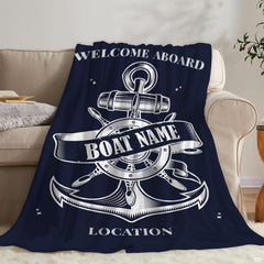 Close-up view of the white anchor and steering wheel artwork on navy bedding.