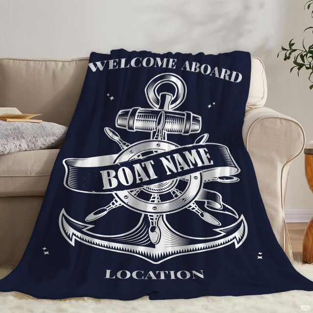 Close-up view of the white anchor and steering wheel artwork on navy bedding.
