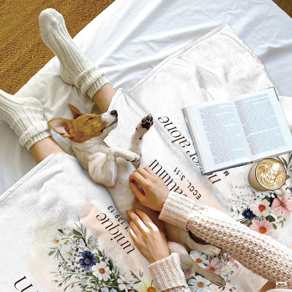 Relaxing indoor scene with puppy and devotional book atop the floral cross scripture blanket.