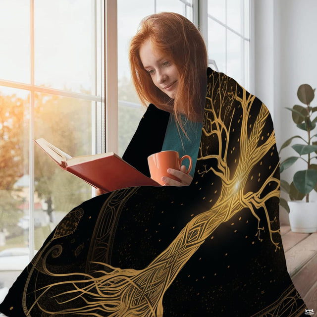 Woman holding open braided Celtic Tree of Life throw blanket showcasing circular runic halo artwork
