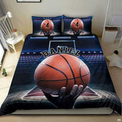 Close-up perspective of sports bedding detailing pebbled basketball grip, fingers, and hardwood court lanes