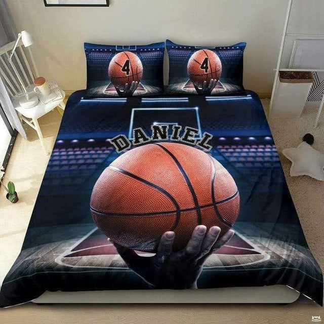 Close-up perspective of sports bedding detailing pebbled basketball grip, fingers, and hardwood court lanes