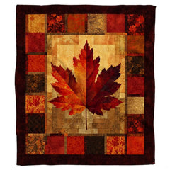 Rustic autumn maple leaf throw blanket featuring a two-tone crimson and amber leaf on patchwork calico tiles