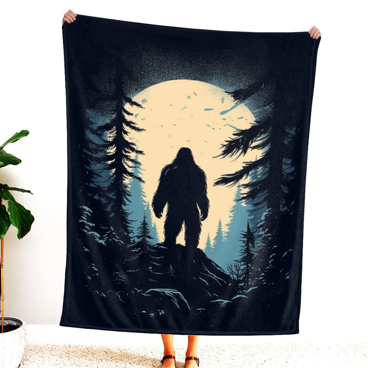 Close-up of Sasquatch silhouette atop rocky ridge and glowing moon backdrop.