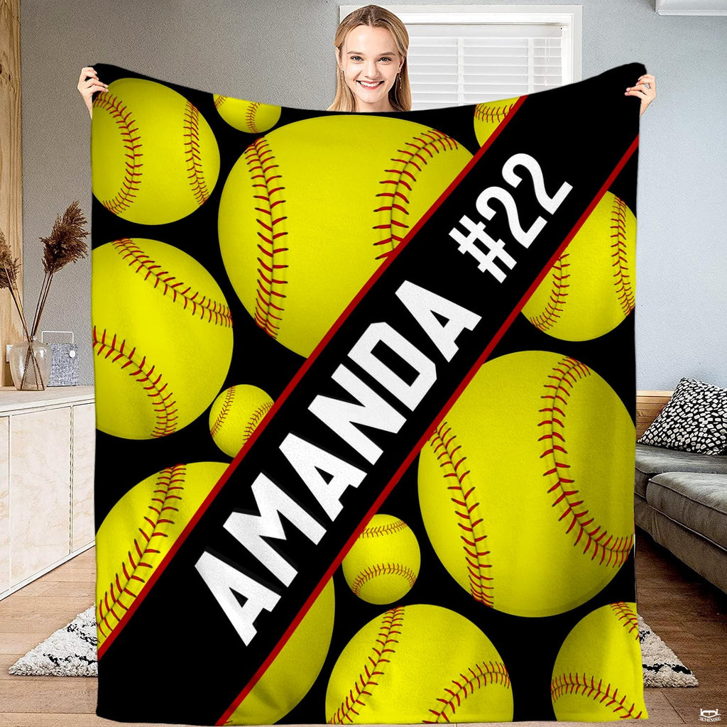 Front view of diagonal sash softball throw blanket displaying floating yellow softballs on black ground.