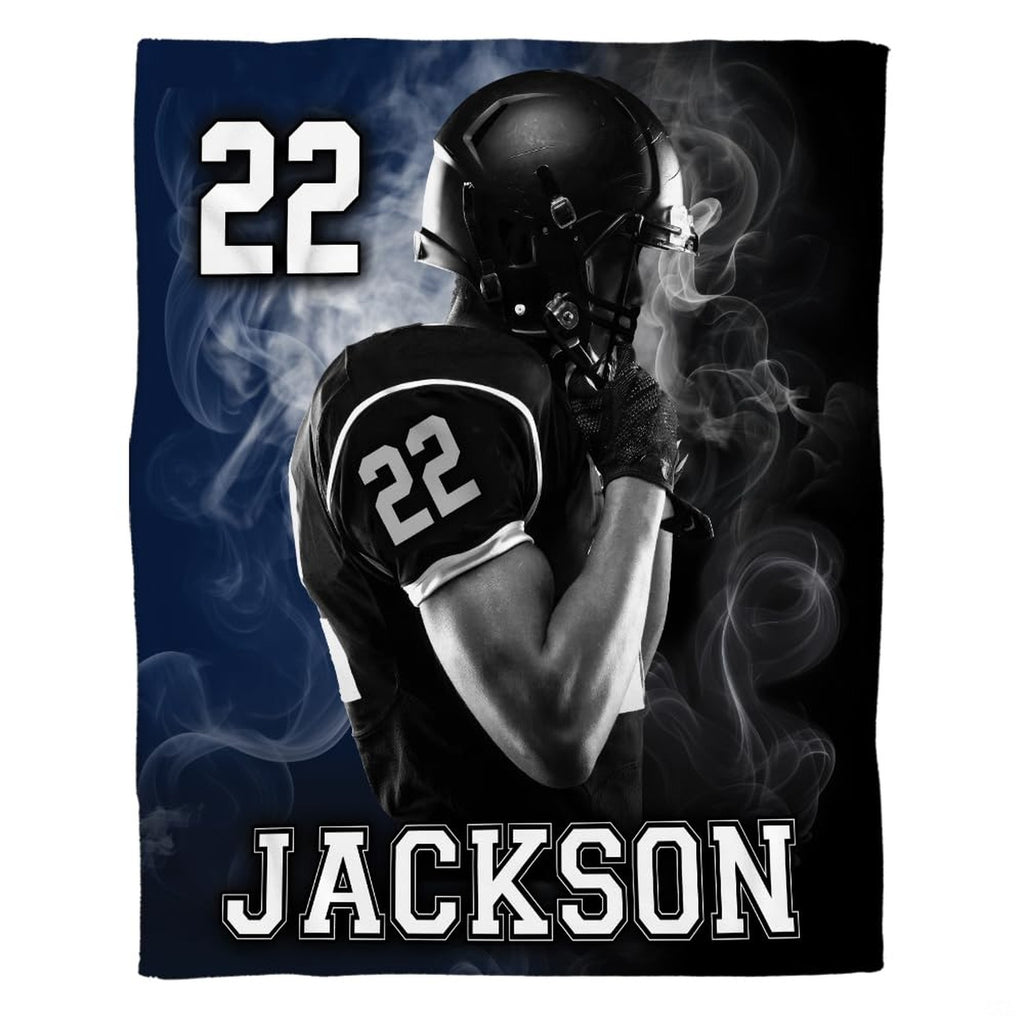 Woman holding open football player throw blanket showing bold varsity typography and smoke clouds