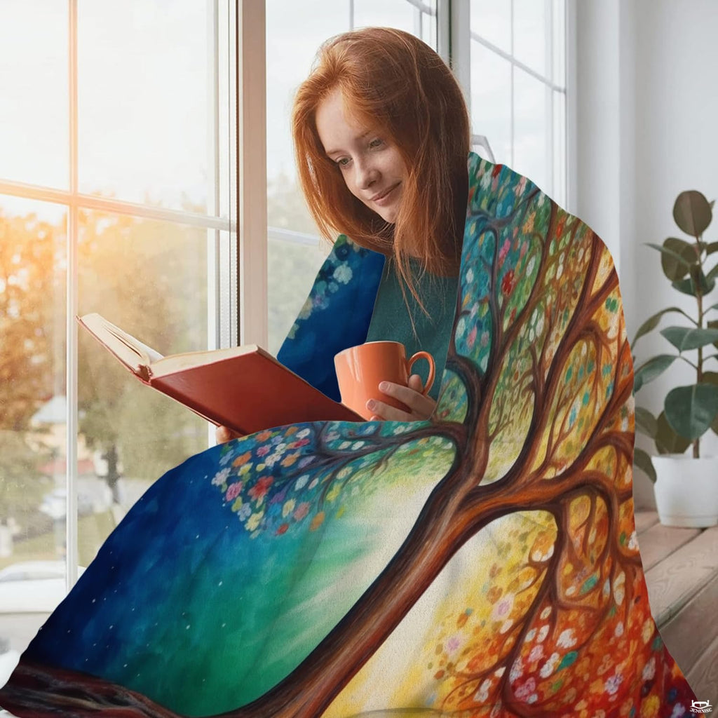 Woman holding open Four Seasons Tree of Life throw blanket showing radiant sunbeam artwork