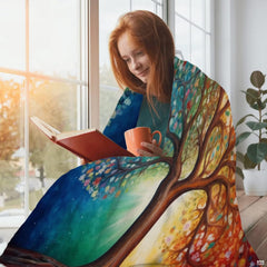 Woman holding open Four Seasons Tree of Life throw blanket showing radiant sunbeam artwork
