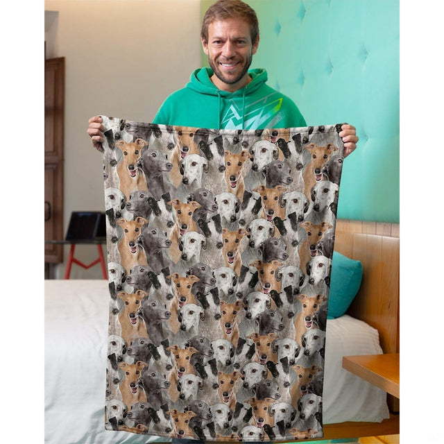 Person holding up a Greyhound dog collage blanket in an indoor domestic room setting.