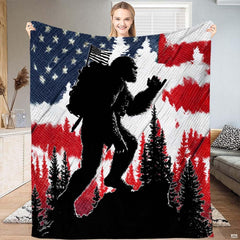 Patriotic Bigfoot hiking throw blanket featuring Sasquatch backpacker against American flag stars and stripes