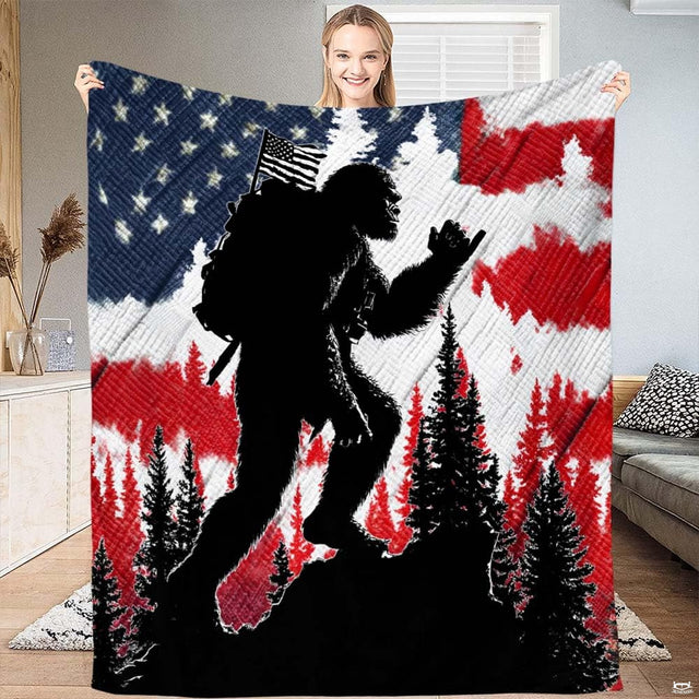 Patriotic Bigfoot hiking throw blanket featuring Sasquatch backpacker against American flag stars and stripes