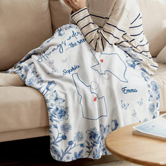 Detail of blue botanical throw blanket highlighting delicate butterfly motifs and red heart markers
