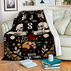 Gothic romance skull throw blanket styled across a bed in a dark moody room.