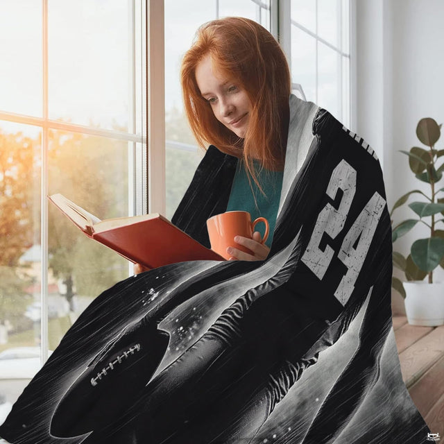 Football storm textile draped over woman reading beside window