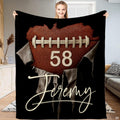 Football heart throw blanket held upright showing pebble leather heart and ripped paper artwork.
